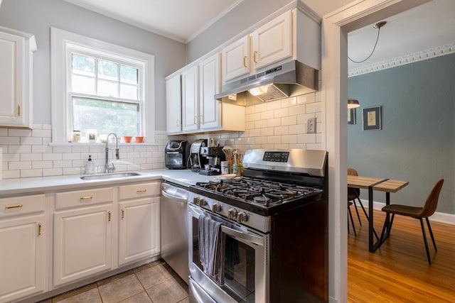 kitchen with sink, white cabinets, decorative backsplash, and stainless steel appliances