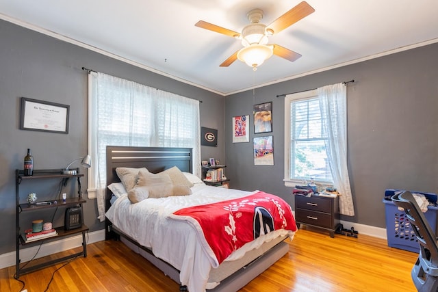 bedroom featuring light hardwood / wood-style floors, ornamental molding, and ceiling fan