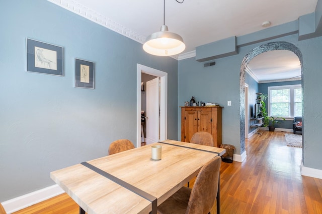 dining area featuring crown molding and hardwood / wood-style floors