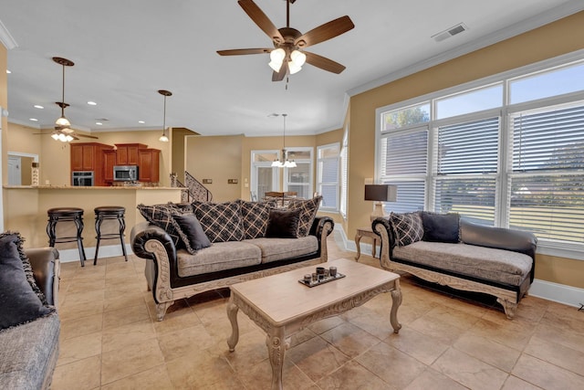 tiled living room with ornamental molding and ceiling fan with notable chandelier