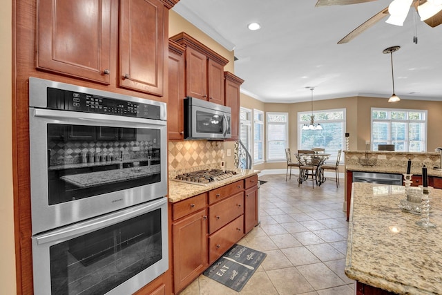 kitchen featuring decorative backsplash, stainless steel appliances, crown molding, pendant lighting, and light tile patterned floors