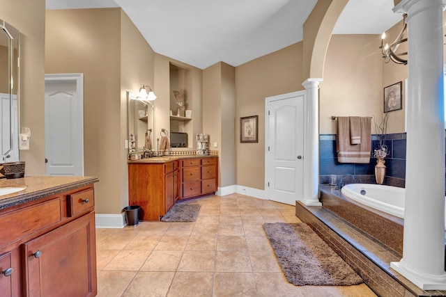 bathroom featuring vanity, a chandelier, a relaxing tiled tub, and tile patterned floors