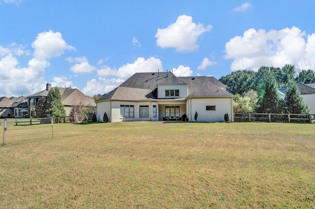 rear view of property featuring a lawn