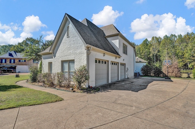 view of side of property with a garage, central air condition unit, and a lawn