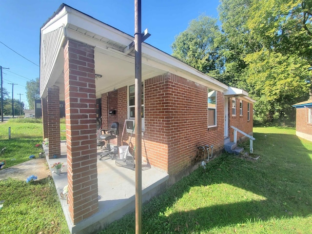 view of side of home featuring a yard and a patio