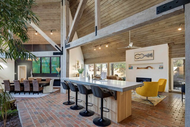 kitchen featuring wood ceiling, high vaulted ceiling, and a fireplace