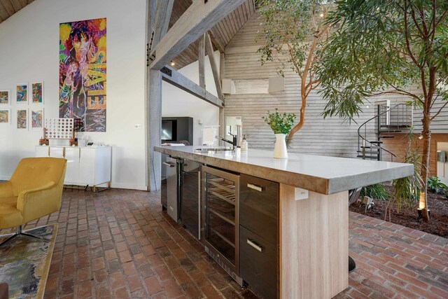 kitchen with a breakfast bar, high vaulted ceiling, and beverage cooler