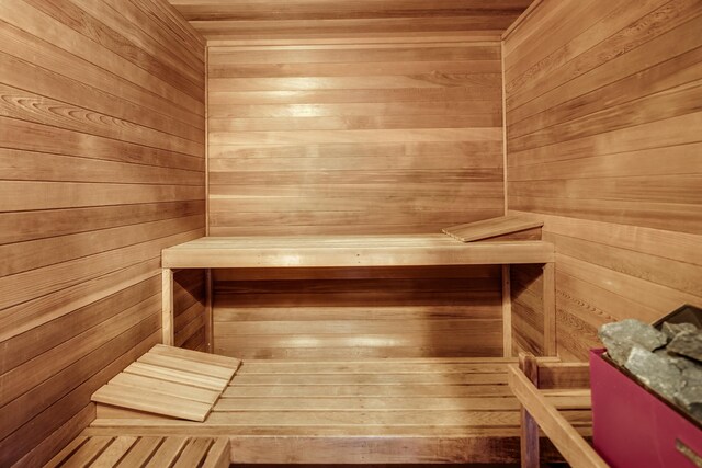 view of sauna featuring wooden walls