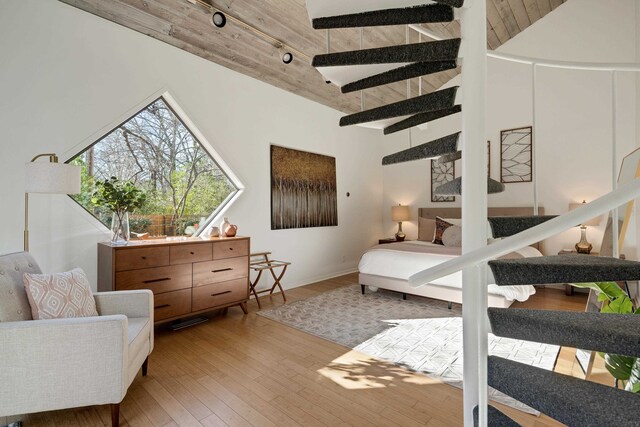 bedroom featuring wood ceiling, high vaulted ceiling, track lighting, and light wood-type flooring