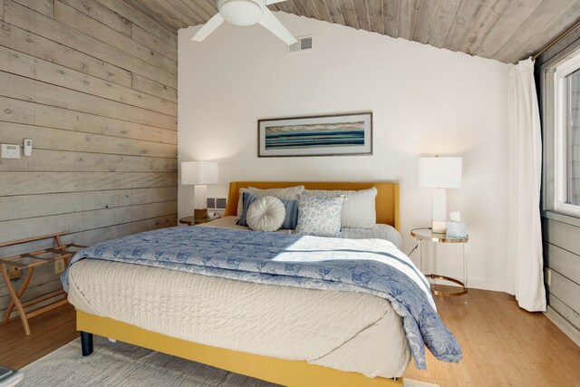 bedroom featuring wood ceiling, wood walls, vaulted ceiling, and ceiling fan