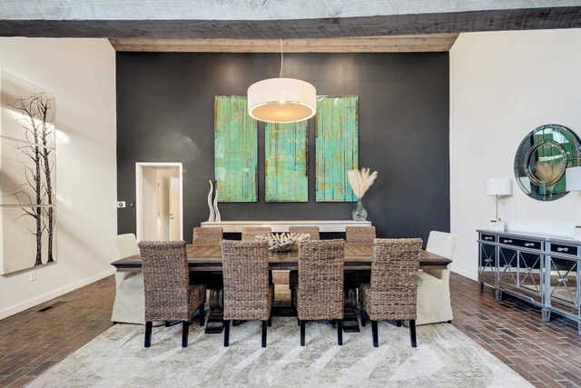 dining area featuring beam ceiling