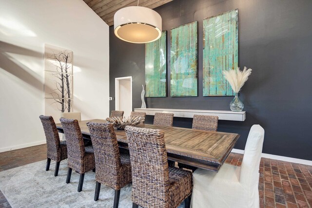 dining space with high vaulted ceiling