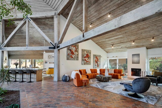 living room featuring high vaulted ceiling, wooden ceiling, a wealth of natural light, and beamed ceiling