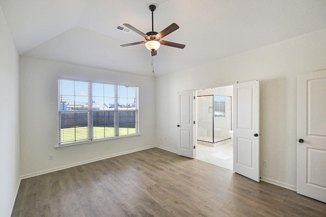 spare room with vaulted ceiling, dark hardwood / wood-style floors, and ceiling fan