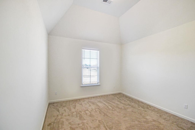 empty room with vaulted ceiling and light carpet