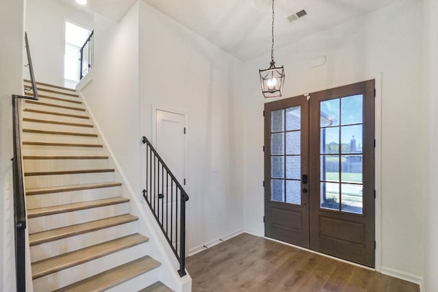 entryway featuring french doors, a notable chandelier, and dark hardwood / wood-style floors