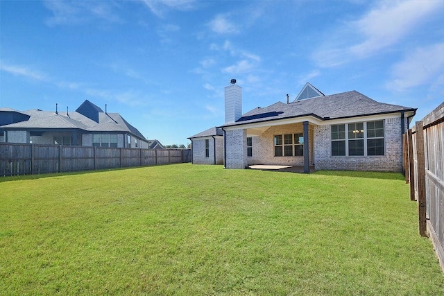 back of house featuring a patio and a yard