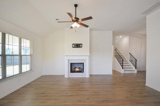 unfurnished living room with dark wood-type flooring, ceiling fan, lofted ceiling, and a fireplace