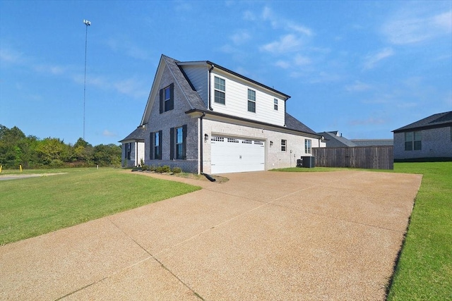 view of front of property with central AC, a front yard, and a garage