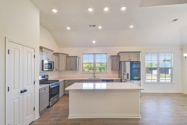 kitchen with a center island, stainless steel appliances, dark wood-type flooring, and a wealth of natural light