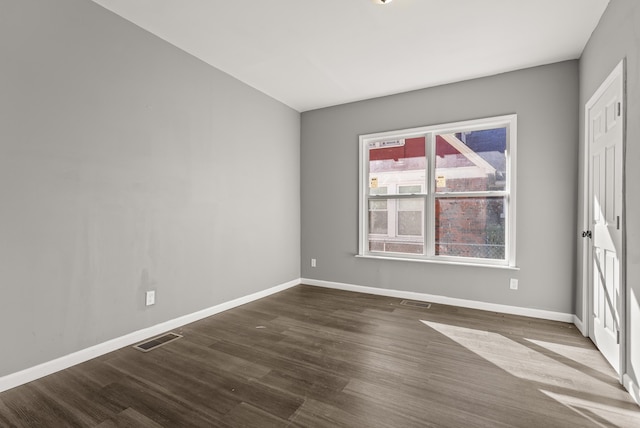 unfurnished room with dark hardwood / wood-style flooring