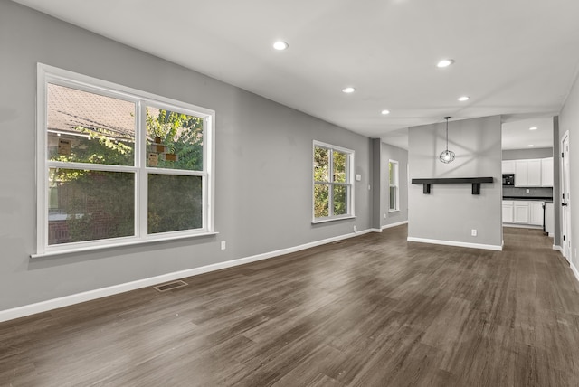 unfurnished living room featuring dark hardwood / wood-style floors