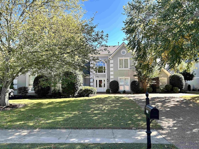 view of property hidden behind natural elements featuring a front yard