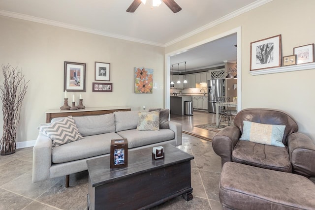 living room featuring ceiling fan, ornamental molding, and sink