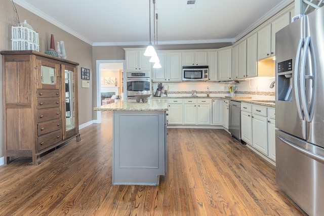 kitchen with dark wood-type flooring, appliances with stainless steel finishes, light stone counters, and pendant lighting