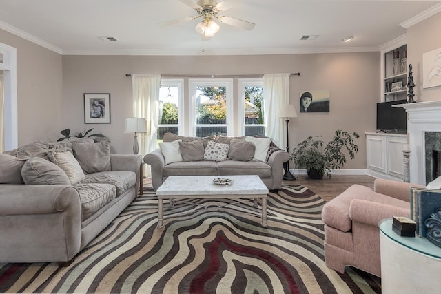 living room with crown molding, ceiling fan, a fireplace, and dark hardwood / wood-style flooring