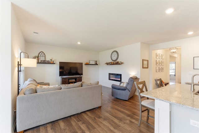 living room featuring sink and dark hardwood / wood-style flooring