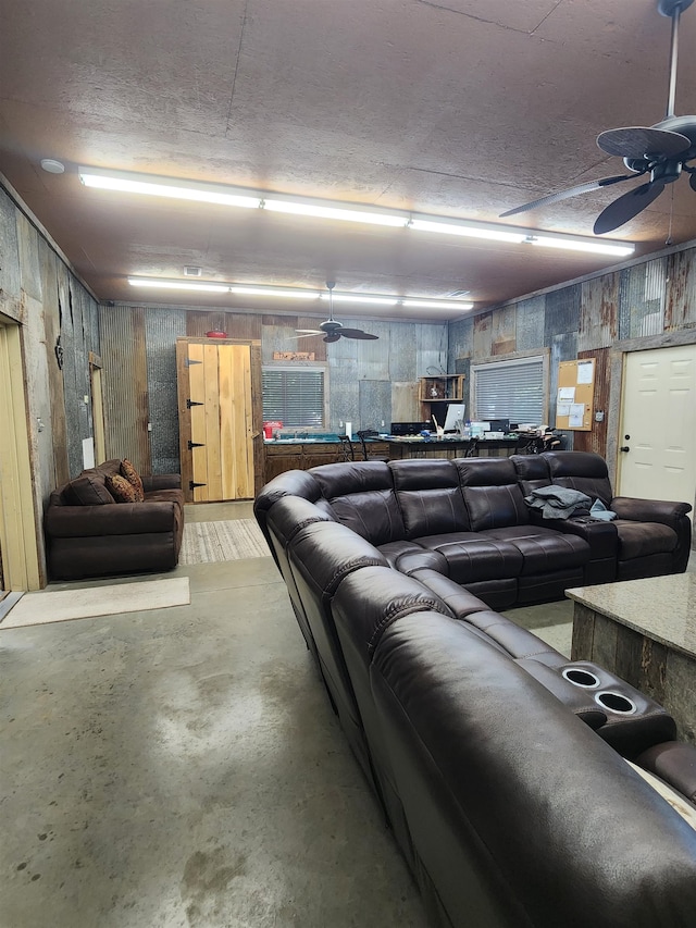 cinema room featuring concrete flooring and ceiling fan