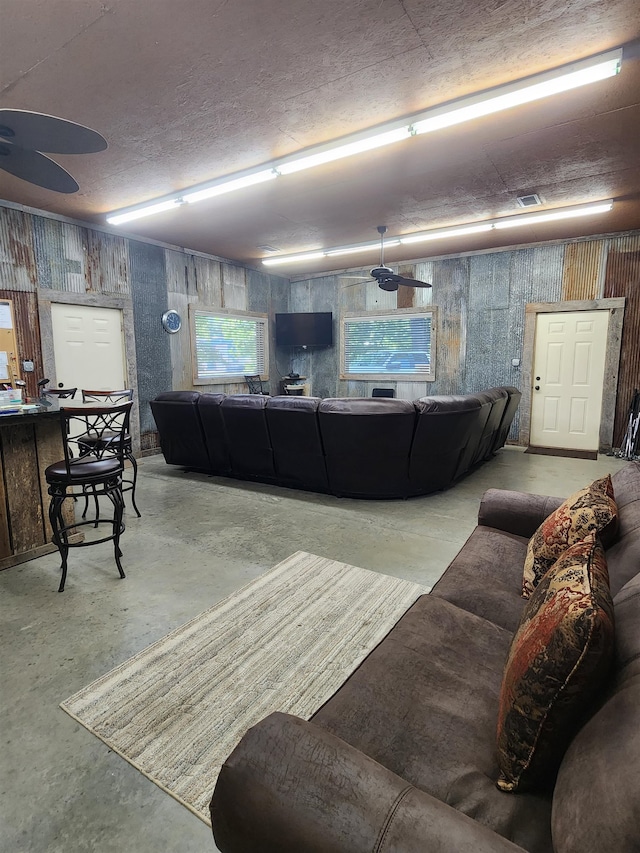 living room with concrete flooring and ceiling fan