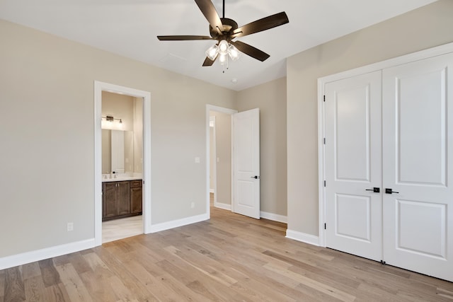 unfurnished bedroom featuring ceiling fan, a closet, ensuite bathroom, and light wood-type flooring