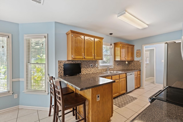 kitchen with pendant lighting, appliances with stainless steel finishes, a breakfast bar area, and a wealth of natural light