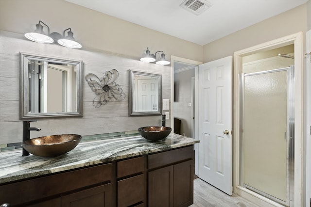 bathroom featuring vanity, walk in shower, and wood-type flooring