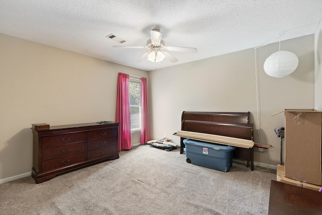 misc room with a textured ceiling, light colored carpet, and ceiling fan