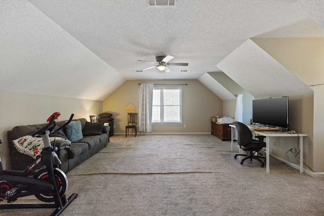 carpeted office space with lofted ceiling, a textured ceiling, built in desk, and ceiling fan