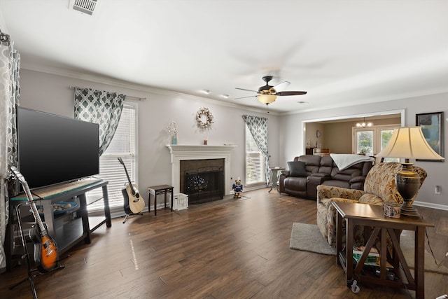 living room with ornamental molding, dark wood-type flooring, and ceiling fan