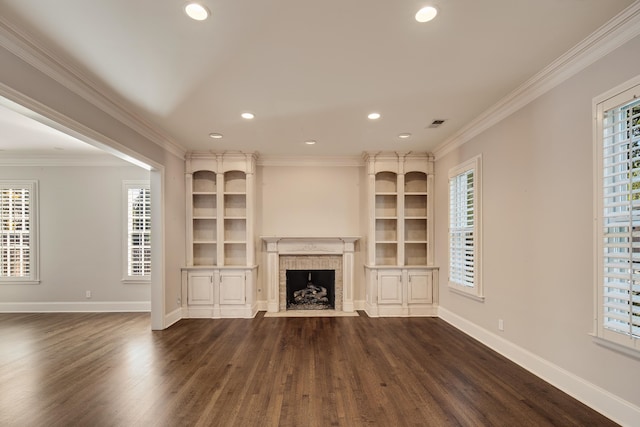 unfurnished living room with dark wood-type flooring, crown molding, a brick fireplace, and plenty of natural light