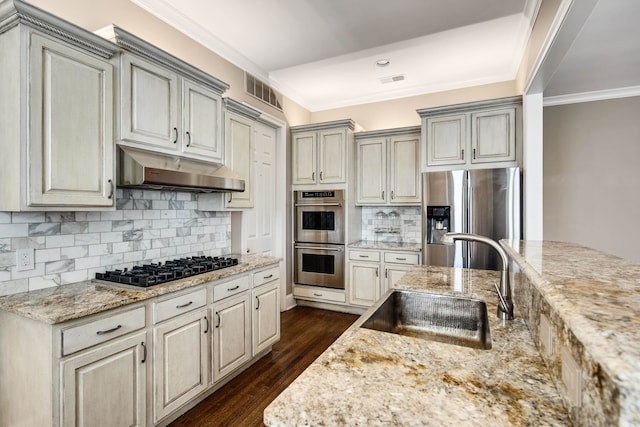 kitchen featuring appliances with stainless steel finishes, sink, light stone counters, ornamental molding, and dark hardwood / wood-style floors