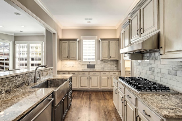 kitchen with light stone countertops, ornamental molding, stainless steel appliances, decorative backsplash, and dark hardwood / wood-style floors