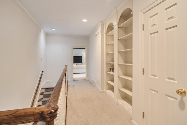 corridor with crown molding and light colored carpet