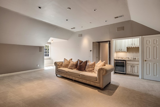 carpeted living room featuring wine cooler, high vaulted ceiling, and sink