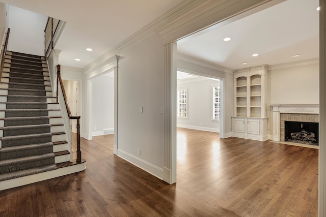 unfurnished living room featuring crown molding and wood-type flooring