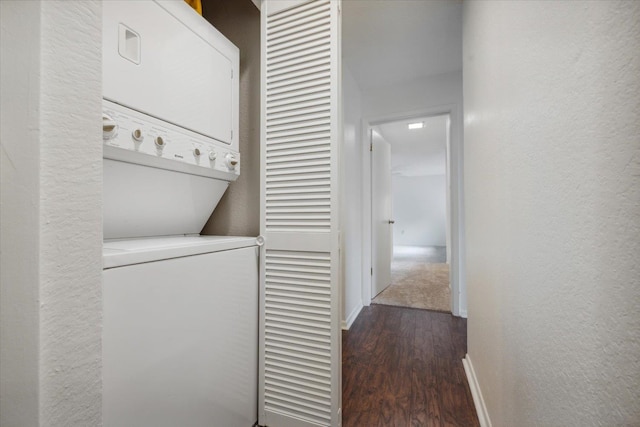 laundry area with dark hardwood / wood-style floors and stacked washer / dryer