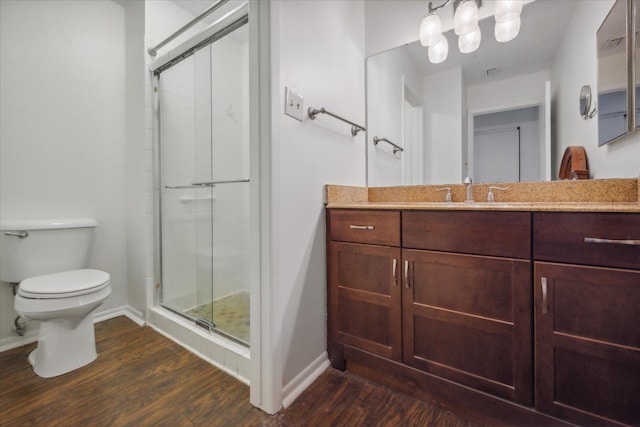 bathroom featuring toilet, an enclosed shower, hardwood / wood-style floors, and vanity