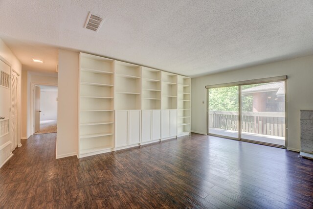 unfurnished living room featuring a textured ceiling and dark hardwood / wood-style flooring