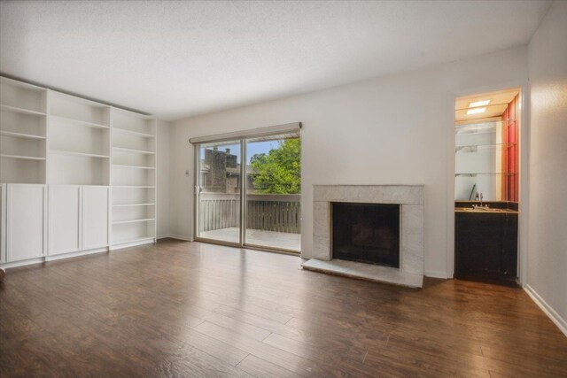 unfurnished living room with dark wood-type flooring and a textured ceiling