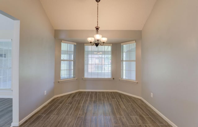 unfurnished dining area featuring an inviting chandelier, dark wood-type flooring, vaulted ceiling, and a healthy amount of sunlight